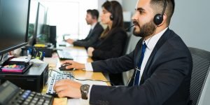 attractive-latin-executive-offering-customer-service-with-headset-offering-tech-support-busy-call-center